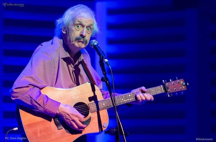Peter Buckley Hill singing with an acoustic guitar on stage